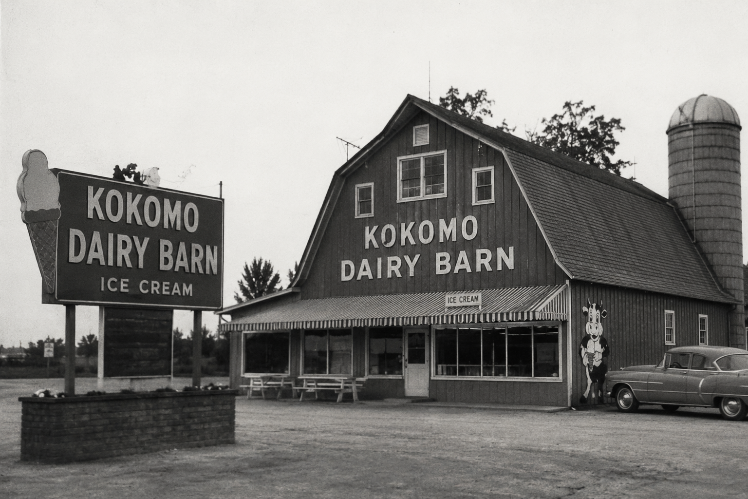 The Kokomo Dairy Barn exterior with its large sign, red barn, and a classic 1950s car in the lot